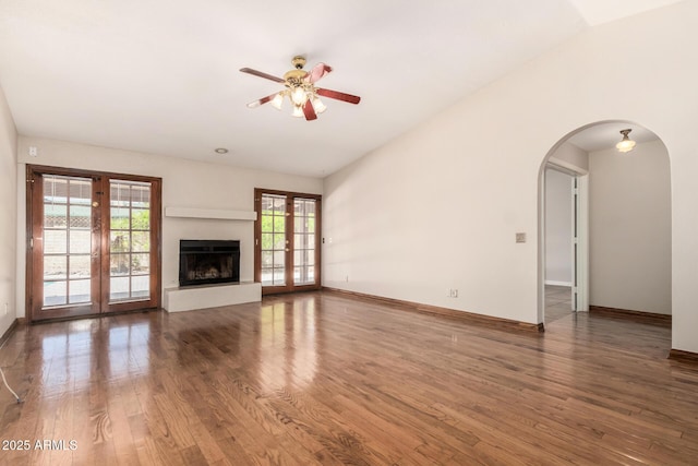 16216 N Runyon Pl, Fountain Hills, AZ 85268 - unfurnished living room with ceiling fan, wood finished floors, baseboards, arched walkways, and a fireplace with raised hearth