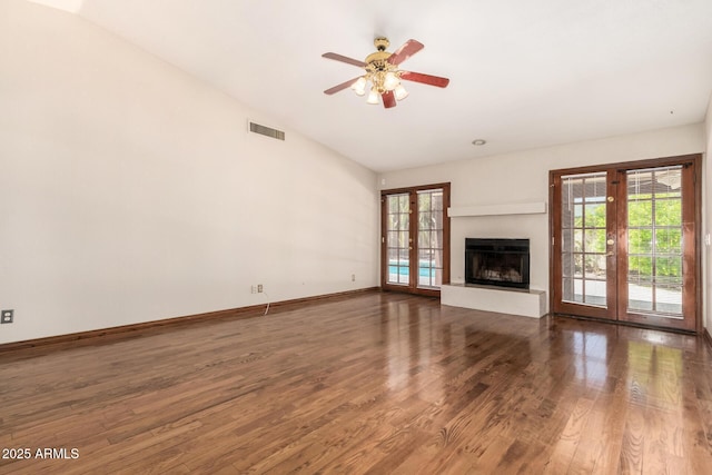 16216 N Runyon Pl, Fountain Hills, AZ 85268 - unfurnished living room featuring healthy amount of natural light, wood finished floors, vaulted ceiling, a ceiling fan, and a fireplace with raised hearth