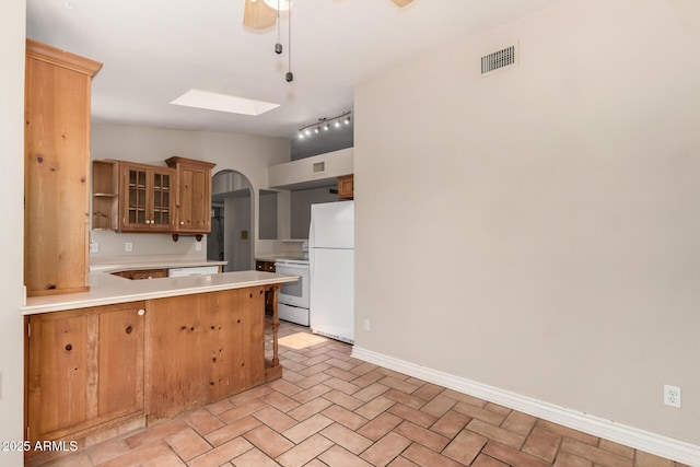 16216 N Runyon Pl, Fountain Hills, AZ 85268 - kitchen with white appliances, a peninsula, a skylight, light countertops, and vaulted ceiling