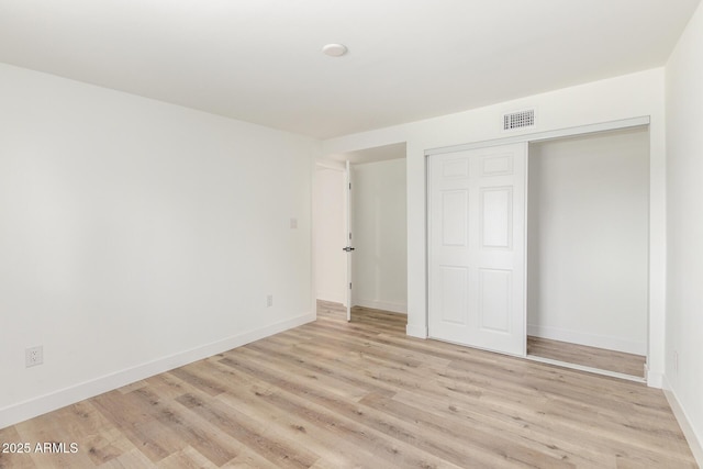 unfurnished bedroom featuring a closet and light hardwood / wood-style flooring