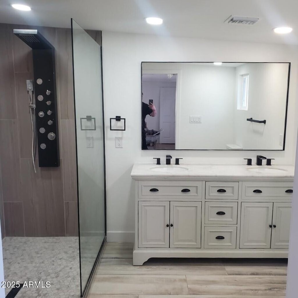 bathroom featuring a shower, wood-type flooring, and vanity