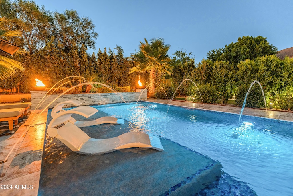 view of pool featuring pool water feature and a hot tub