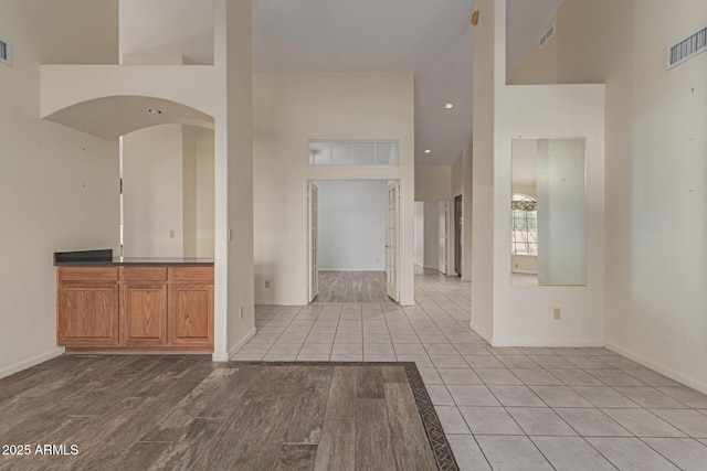 spare room with a high ceiling and light hardwood / wood-style floors