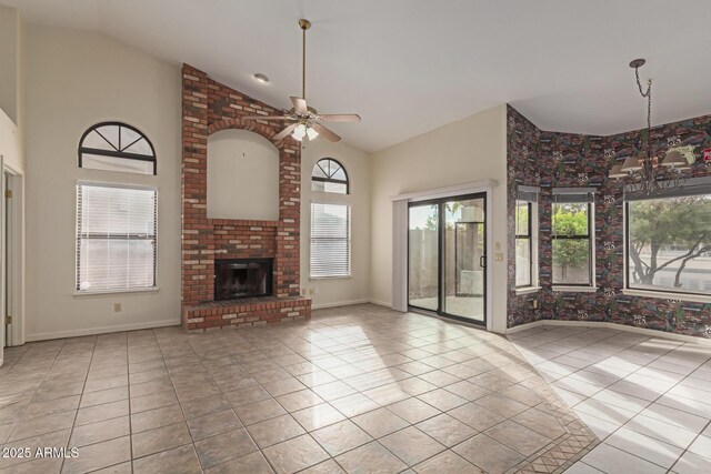 unfurnished living room featuring light tile patterned flooring, high vaulted ceiling, ceiling fan, and a fireplace