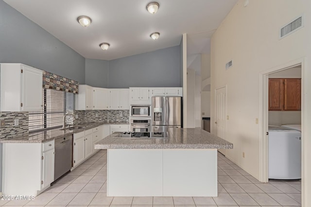 kitchen with white cabinetry, appliances with stainless steel finishes, sink, and a center island