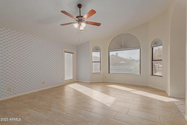 tiled empty room featuring vaulted ceiling and ceiling fan