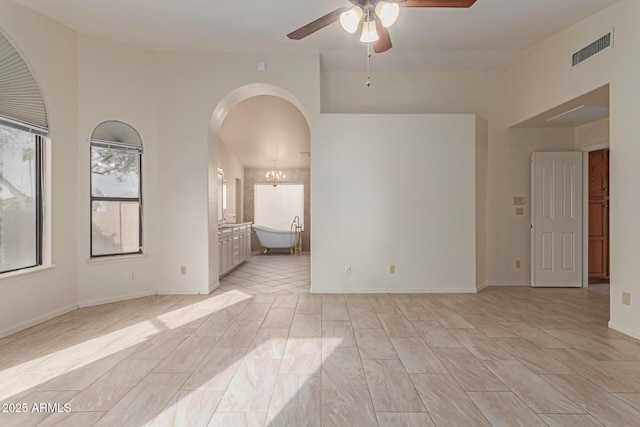 empty room featuring ceiling fan with notable chandelier