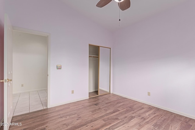 unfurnished bedroom with light wood-type flooring, a closet, and ceiling fan