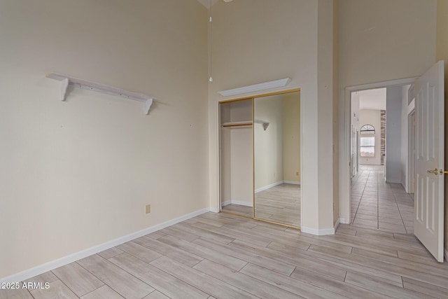 unfurnished bedroom featuring a towering ceiling and a closet