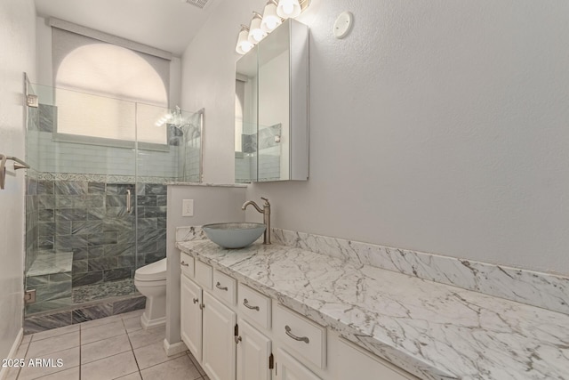 bathroom with toilet, vanity, tile patterned flooring, and an enclosed shower