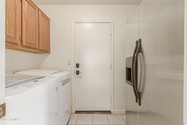 laundry room with washing machine and dryer, light tile patterned floors, and cabinets