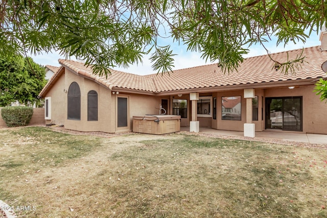 back of house with a yard, a patio, and a hot tub