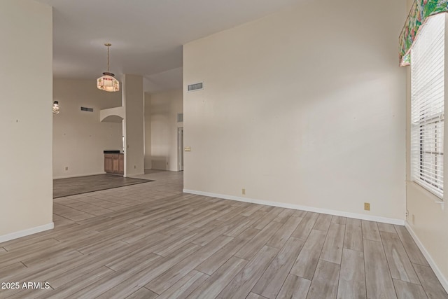 spare room with light hardwood / wood-style flooring and vaulted ceiling