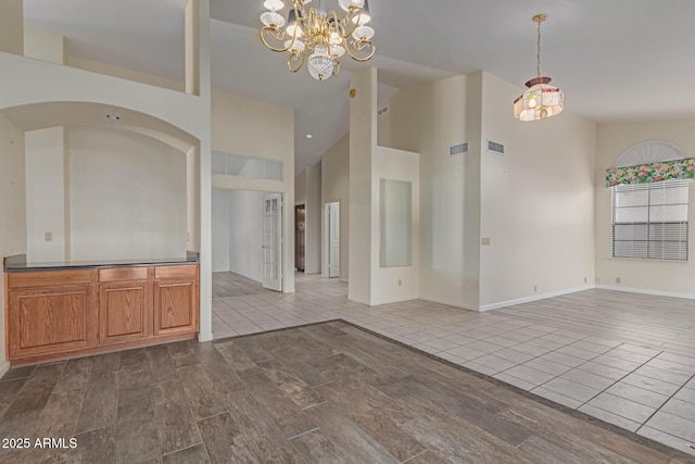 interior space with a notable chandelier, high vaulted ceiling, and wood-type flooring