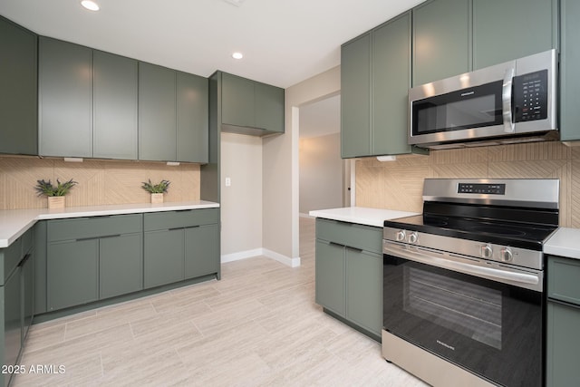 4506 W Golden Ln, Glendale, AZ 85302 - kitchen with green cabinetry, tasteful backsplash, stainless steel appliances, and light countertops