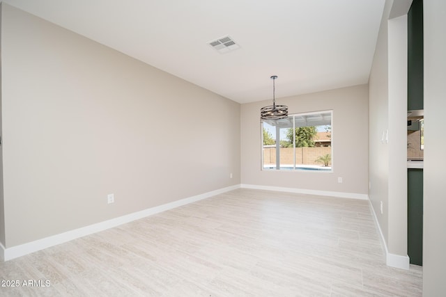 4506 W Golden Ln, Glendale, AZ 85302 - unfurnished room with light wood finished floors, an inviting chandelier, visible vents, and baseboards