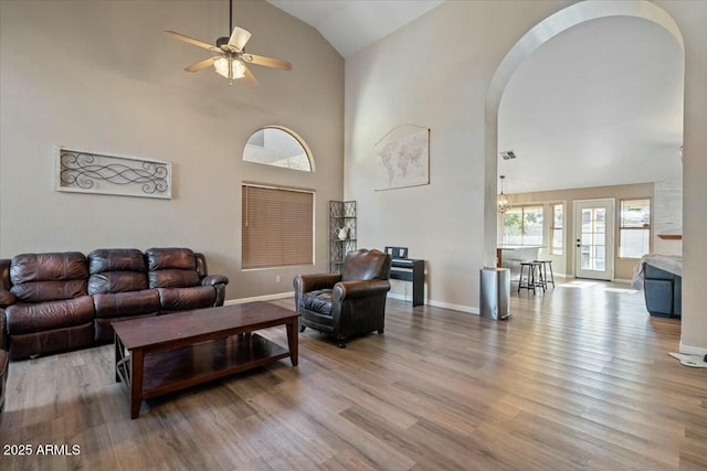 living room with high vaulted ceiling, light hardwood / wood-style flooring, and ceiling fan