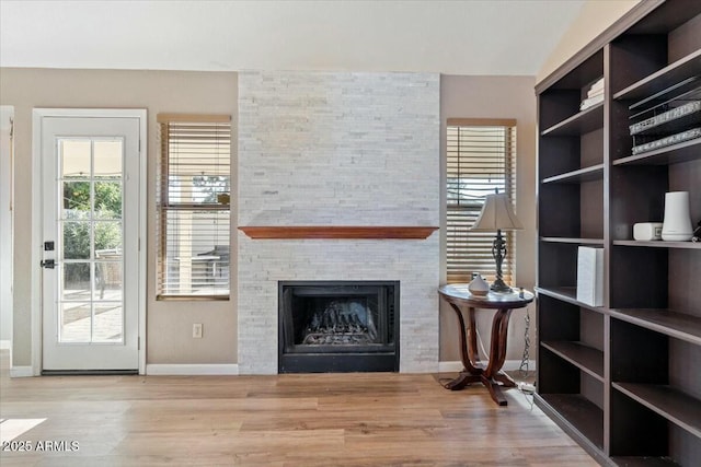 unfurnished living room with a fireplace and light wood-type flooring