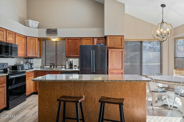 kitchen featuring a center island, an inviting chandelier, and black appliances