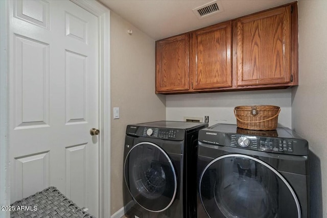 washroom featuring cabinets and washing machine and dryer