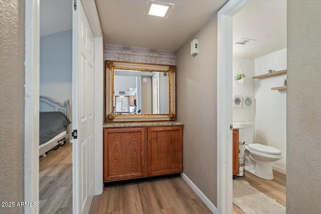 bathroom with wood-type flooring, vanity, and toilet