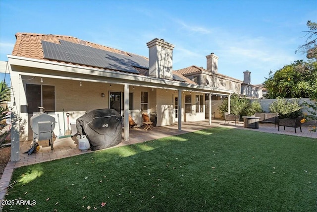 back of property featuring solar panels, a yard, and a patio