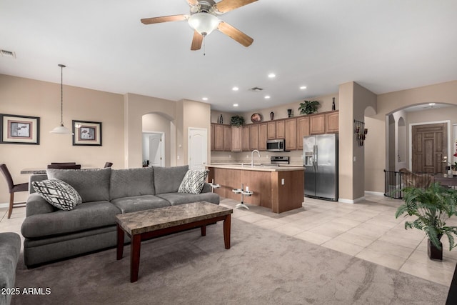 tiled living room with sink and ceiling fan