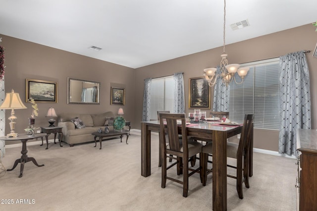 carpeted dining room with a chandelier