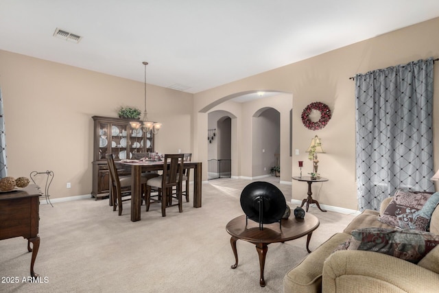 dining room featuring a chandelier and light colored carpet