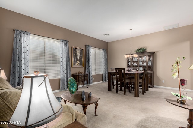 carpeted living room with an inviting chandelier