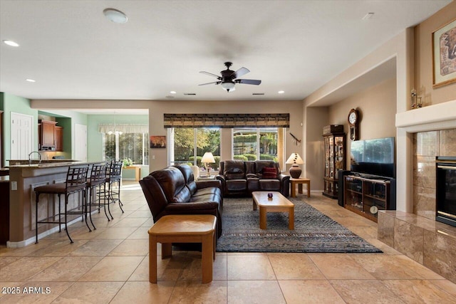 living room with sink, light tile patterned flooring, and ceiling fan with notable chandelier