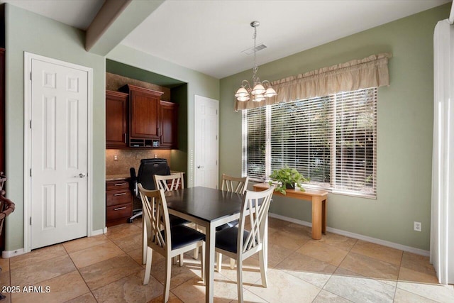 tiled dining area with plenty of natural light, beamed ceiling, and a chandelier