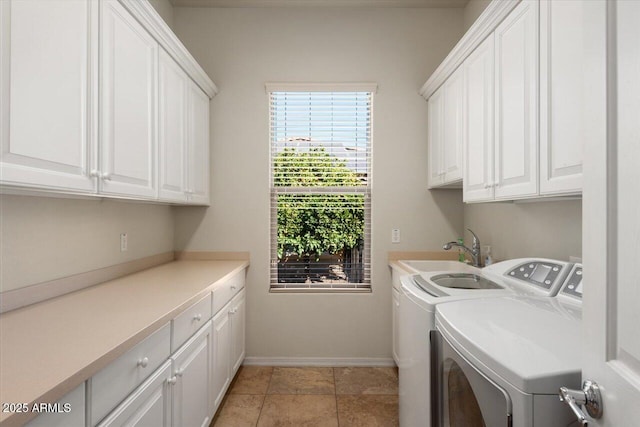 laundry area featuring cabinets, light tile patterned floors, washing machine and dryer, and sink