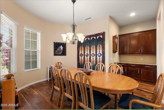 dining room with a healthy amount of sunlight, a chandelier, and dark hardwood / wood-style floors