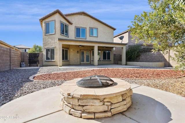 back of property featuring a patio area, ceiling fan, and an outdoor fire pit