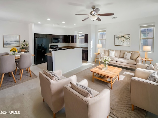 living room featuring ceiling fan and a wealth of natural light