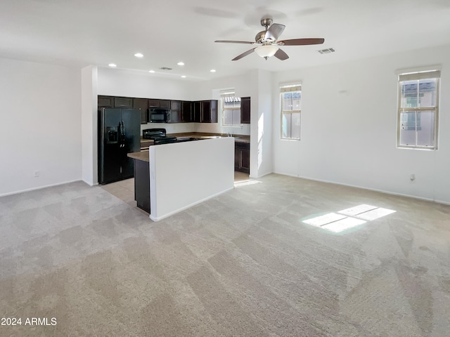 kitchen featuring light carpet, black appliances, a center island, and ceiling fan