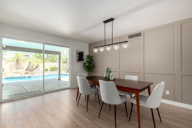 dining room with a decorative wall and light wood-style floors