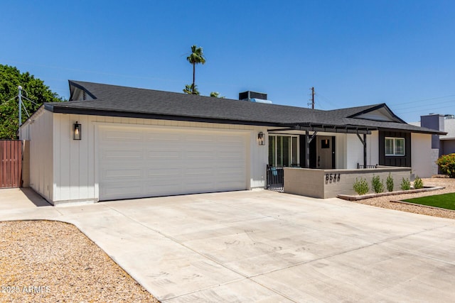 ranch-style home with driveway, a garage, a shingled roof, and covered porch