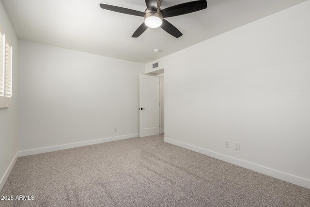carpeted empty room featuring a ceiling fan and baseboards