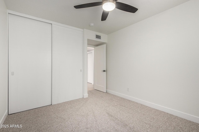 unfurnished bedroom featuring carpet flooring, a closet, baseboards, and ceiling fan