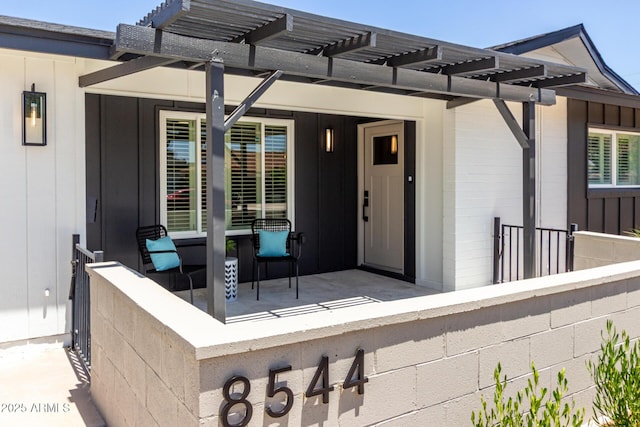 property entrance with a pergola
