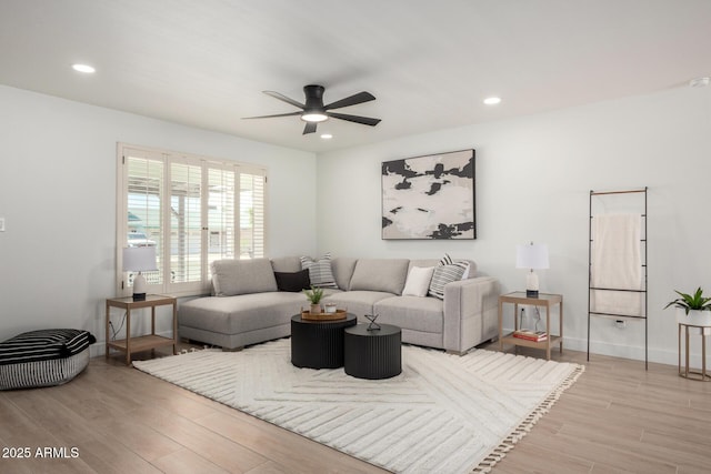 living room featuring a ceiling fan, light wood-style floors, recessed lighting, and baseboards