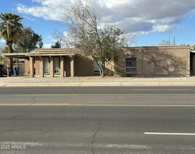 view of front facade with a carport and brick siding