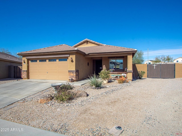 view of front of house featuring an attached garage, driveway, a tiled roof, a gate, and stucco siding