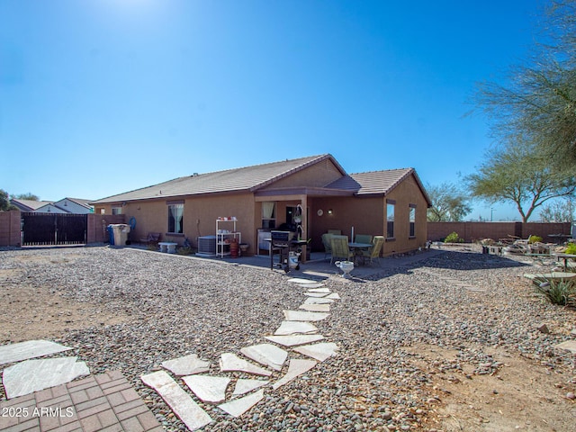 rear view of house featuring a fenced backyard, central air condition unit, a tile roof, stucco siding, and a patio area