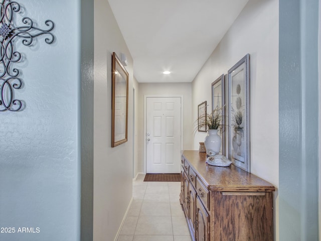 corridor featuring light tile patterned floors and baseboards