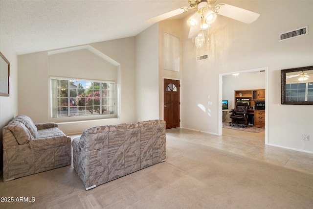 carpeted living area featuring visible vents, a ceiling fan, tile patterned floors, and high vaulted ceiling