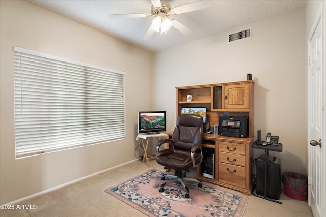 office space with a ceiling fan, a textured ceiling, visible vents, carpet floors, and baseboards