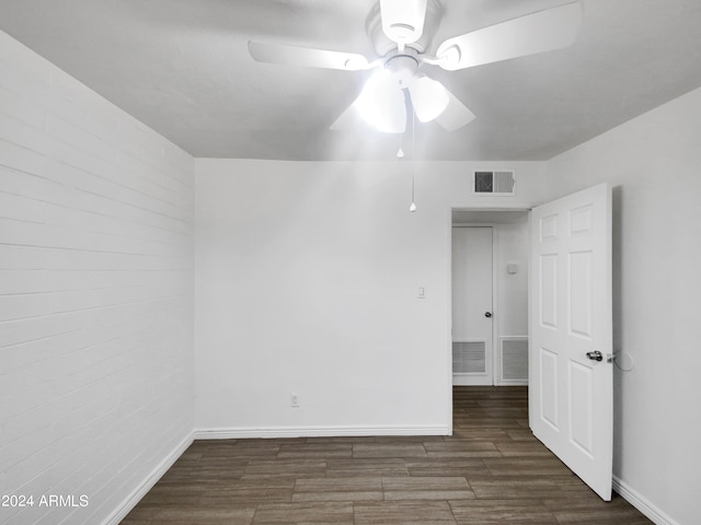 empty room with ceiling fan and dark hardwood / wood-style flooring